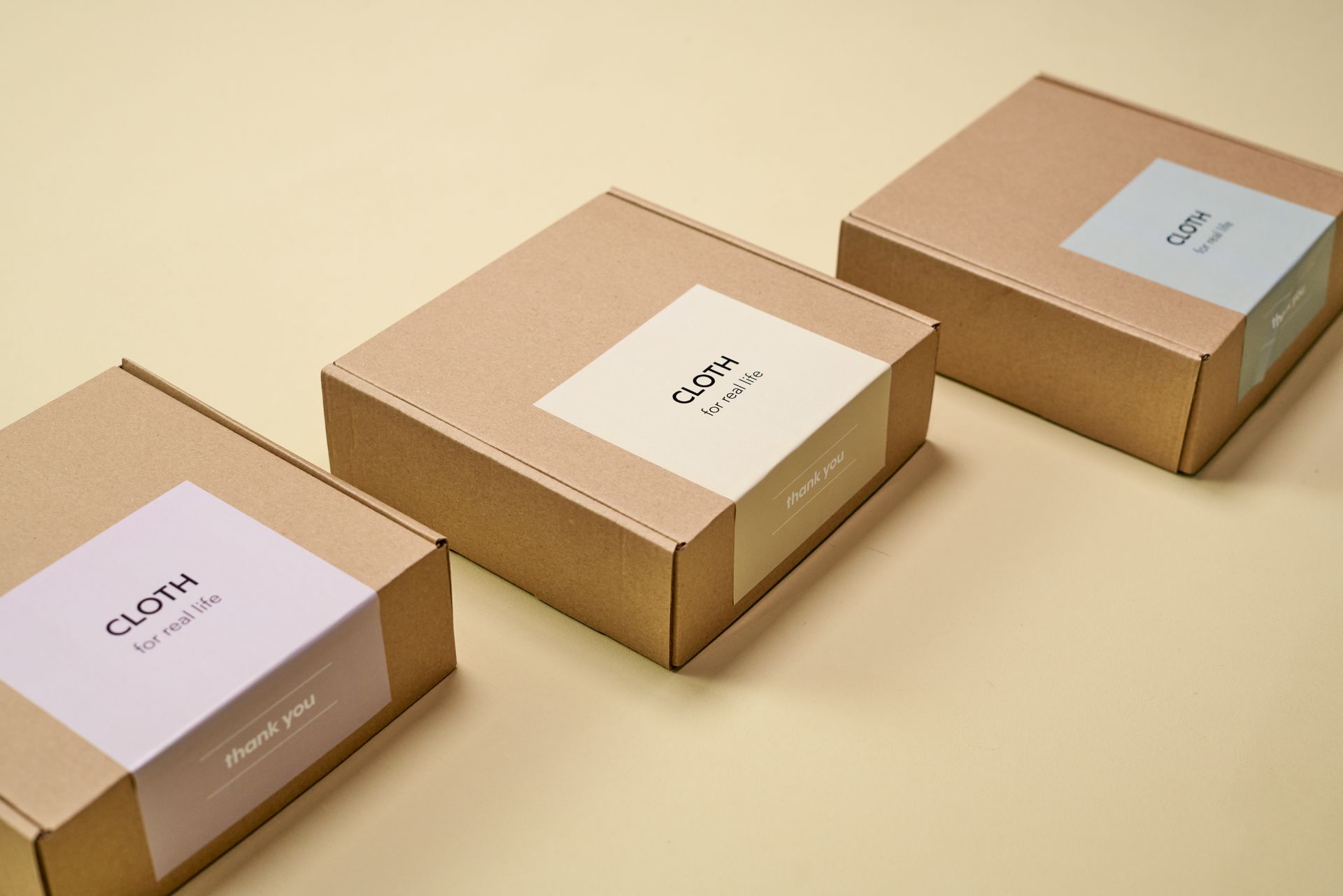 Kraft boxes with printed labels on a cream background